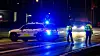 Dänische Polizisten stehen neben einem Polizeiwagen auf der Straße.