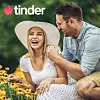 Das Tinder-Logo über einem Paar, das zusammen lacht