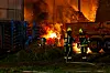 Einsatzkräfte vor der brennenden Lagerhalle.