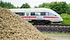 Deutsche Bahn ICE im Hintergrund, vorne links ein Erdhaufen.