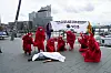 Die Aktivisten trugen rote Gewänder und legten Leichentücher über einen Mann und ein Baby.