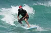 Ein Mann mit Weihnachtsmütze steht auf einem Surfbrett