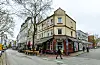 Straßenecke mit einem gelb-roten Haus mit einer Kneipe darin