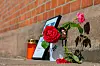 Blumen und Kerzen stehen an einem Bahngebäude. Nach dem Tod einer 16-Jährigen am Bahnhof Friedland sitzt ein Mann per Unterbringungsbefehl in einer psychiatrischen Klinik.