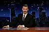 Jimmy Kimmel sitzt in seiner Show hinter dem Schreibtisch in seinem Studio.