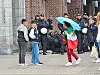 Eine Frau, die eine iranische Flagge trug, soll beleidigt worden sein. Im Hintergrund haben Polizisten ein Mann zu Boden gebracht.