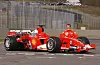 Michael Schuhmacher kniet hinter seinem Ferrari 248 F1