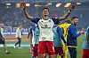 HSV-Stürmer Robert Glatzel steht mit ausgebreiteten Armen vor der Nordtribüne