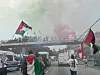 An den Landungsbrücken legt sich grün-roter Rauch über die Demonstration.