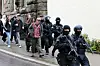 Polizisten führen Schüler und Lehrer aus dem Gebäude.