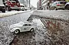 Spielzeigauto in einem Schlagloch