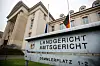 Schild mit Landgericht und Amtsgericht bedruck. Im Hintergrund ist das Gerichtsgebäude Schwerin zu sehen