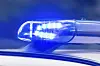 Das Foto zeigt das Blau-Licht auf dem Dach eines Polizeiautos bei Nacht