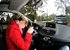 Frau beugt sich über Lenkrad
