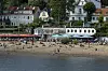 Menschen baden in der Elbe vor den Restaurants Strandperle und Ahoi Strandkiosk am Elbstrand Oevelgönne, Hamburg. (Symbolbild)