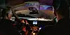 Zwei Polizisten sitzen in einem Auto, man sieht das Cockpit und durch die Frontscheibe eine Autobahn.