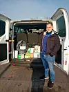 Viktorian Verny, Aktivist bei den Hamburger Linken, vor einem der beladenen Kleinbusse.