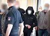 Ein Angeklagter wird in Handschellen in den Gerichtssaal im Strafjustizgebäude geführt (Archivbild).