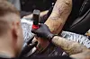 HSV-Tätowierer Tobias Spok sticht ein Tattoo
