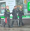 Ein Mann wird von drei Polizisten abgeführt