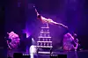 Artist balanciert einhändig auf einer Pyramide aus Sektgläsern