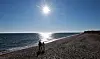 Menschen sind bei strahlendem Sonnenschein und frostigen Temperaturen an der Schönhagener Steilküste an der Ostsee unterwegs.