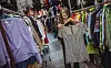 Bigo hält ein kurzes silbernes Glitzerkleid in die Höhe