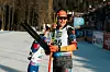Philipp Horn schaut mit Skiern in der Hand Richtung Sonne