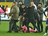 Schiedsrichter Halil Umut Meler liegt am Boden, um ihn herum stehen Spieler und Betreuer.
