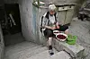 Ljudmila sitzt vor ihrem Keller und entkernt Kirschen.