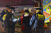 Drei Polizisten kontrollieren einen Jugendlichen