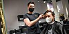 Friseurmeister und Kreativer Leiter des Salons „Engelslocke“ in der Schanze, Emrah Tanriver (34), schneidet seinem ersten Kunden die Haare.
