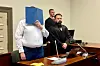 Der 26-jährige Angeklagte steht im Gerichtssaal neben seinem Verteidiger.