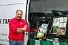 Vorstand Frank Hinrichs steht vor einem offenen Sprinter mit Gemüsekisten.