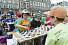 Zwei Kinder beim Schaf spielen. Im Hintergrund ganz viele Kinder die ebenfalls Schach spielen