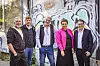 Gruppenbild: Vier Männer und eine Frau mit pinkem Blouson