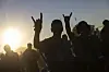 Besucher des Festivals zeigen den 'Horn'-Gruß
