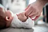Baby hält Händchen mit Mutter