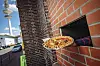 „Einmal vegetarisch, bitte!“: Die Pizza wird durch die Klappe gereicht.