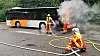 Feuerwehrkräfte löschen das Feuer am Linienbus.