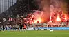 „Holt für uns den Derbysieg“ steht auf einem Banner im Fanblock, es brennt Pyrorechnik.