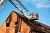 Feuerwehrkräfte auf einer Drehleiter vor dem Wohnhaus in Lüneburg.