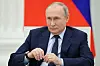 Putin sitzt auf einem Stuhl im Kreml