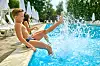 Zwei Kinder planschen im Pool.