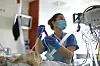 Im Intensiv- und Überwachungsbereich im Klinikum Südstadt wird eine Patientin von Krankenschwester Steffi medizinisch versorgt.