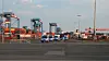Zahlreiche Polizeifahrzeuge fahren vom Gelände des Container-Terminals.