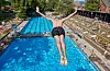 Ein Mann springt vom Zehnmeter Turm in das Becken im Sommerfreibad Kaifu-Bad.
