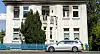 Verrußte und beschädigte Fenster und Balkontüren sind an einem Mehrfamilienhaus zu sehen.