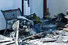 Trümmer liegen vor dem ausgebrannten und explodierten Haus.