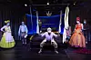 Die Schauspieler und Schauspielerinnen stehen in üppigen Kostümen vor einem Himmelbett